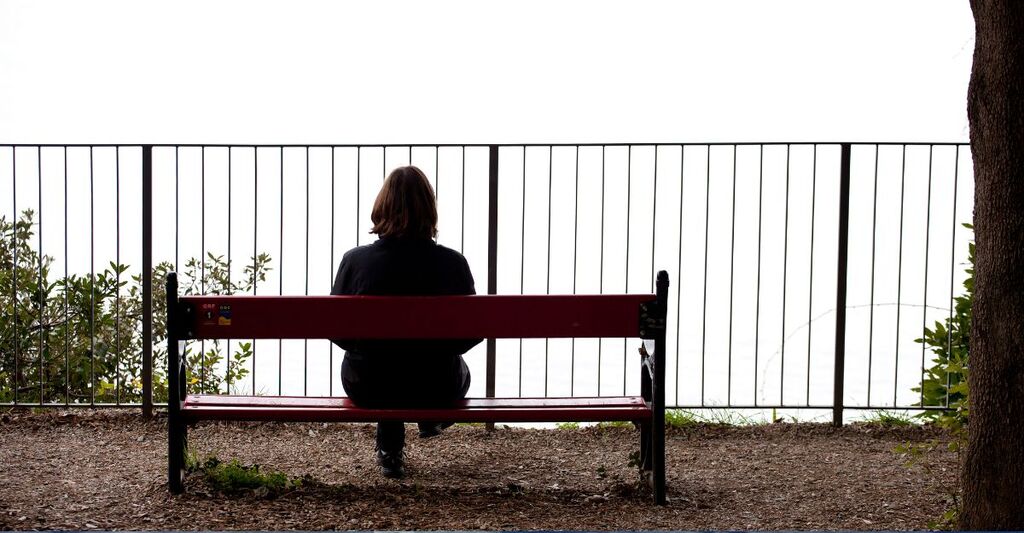 ragazza da sola seduta su una panchina