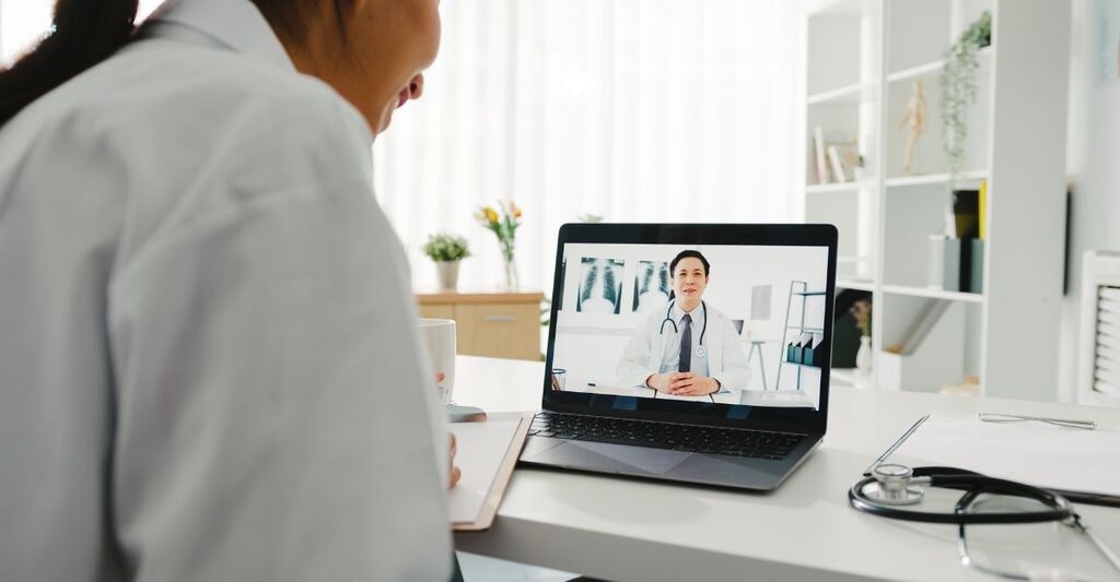 Donna in videoconsulto medico su laptop