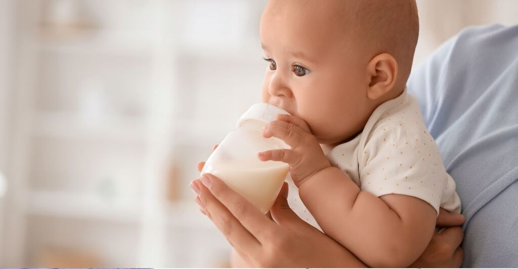 Un bambino beve latte in polvere.