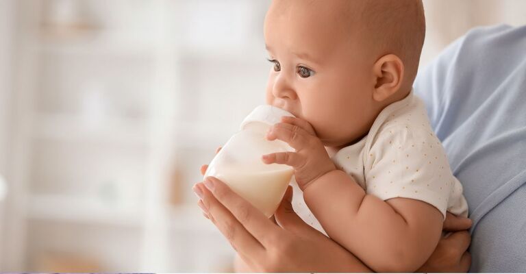 Un bambino beve latte in polvere.