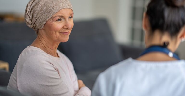 Una donna con cancro parla con il medico dell'orario della terapia.