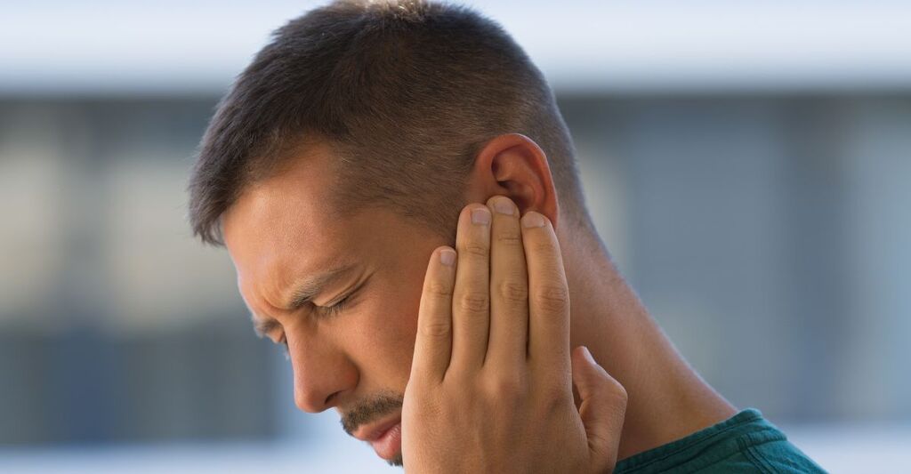 ragazzo si tiene l'orecchio con dolore