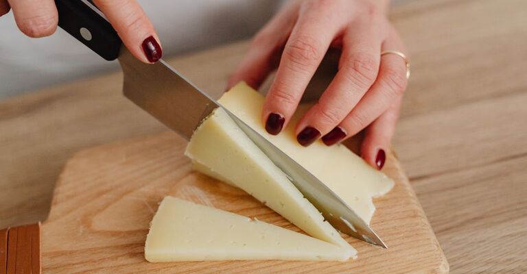 Una donna che taglia del formaggio