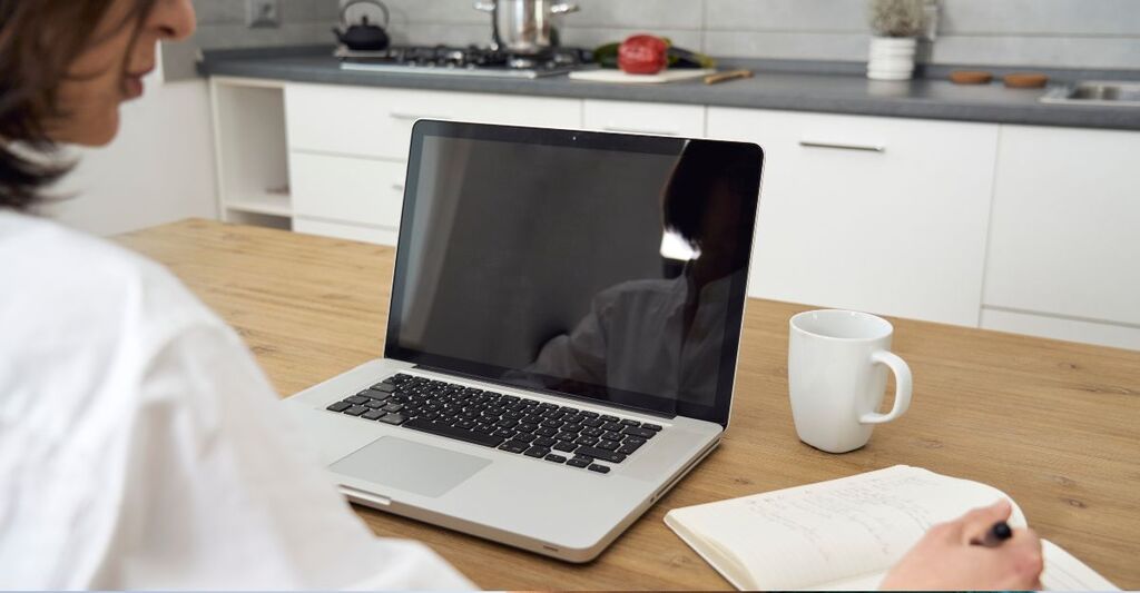 Una donna lavora in smart working favorendo il suo benessere mentale.