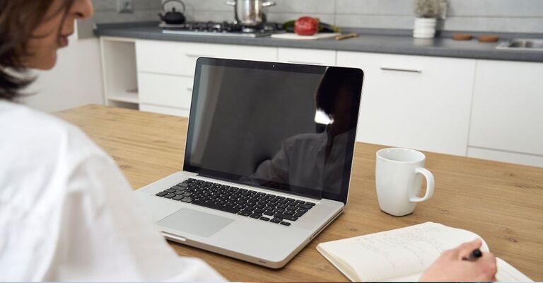 Una donna lavora in smart working favorendo il suo benessere mentale.