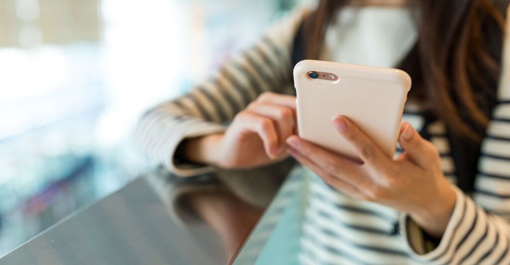 Una ragazza utilizza lo smartphone aumentando il rischio di invecchiamento.