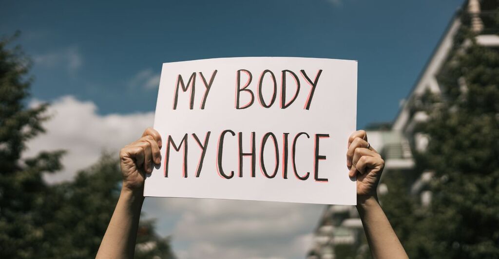 Una persona solleva un cartello bianco con la scritta "MY BODY MY CHOICE" (Il mio corpo, la mia scelta)