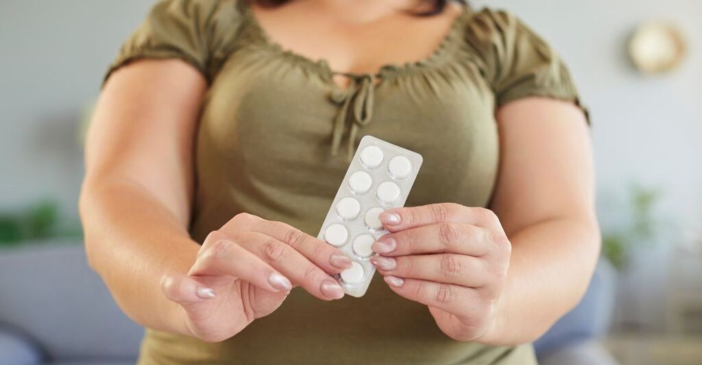 Una donna con i farmaci anti obesità in mano.