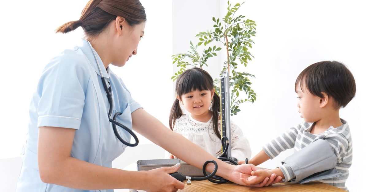Una dottoressa misura la pressione alta ai bambini.