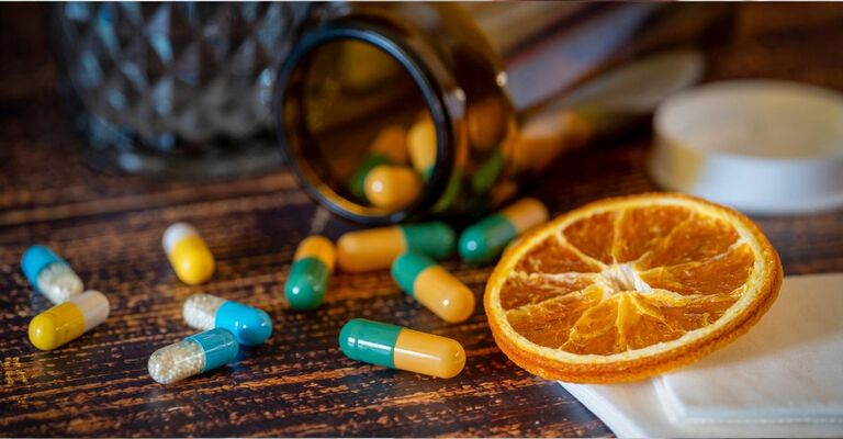 integratori e fetta di arancia