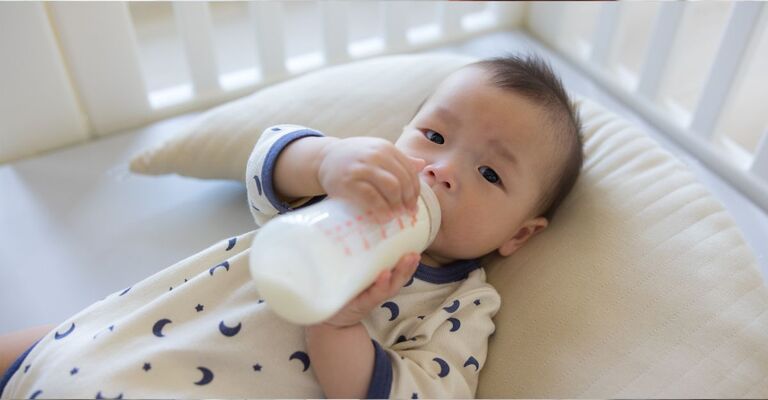 Un neonato beve latte in polvere.