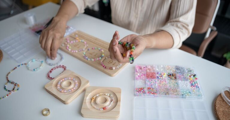 ragazza crea braccialetti con le perline