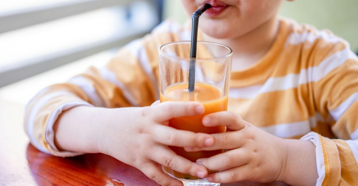 bimbo beve spremuta d'arancia con la cannuccia