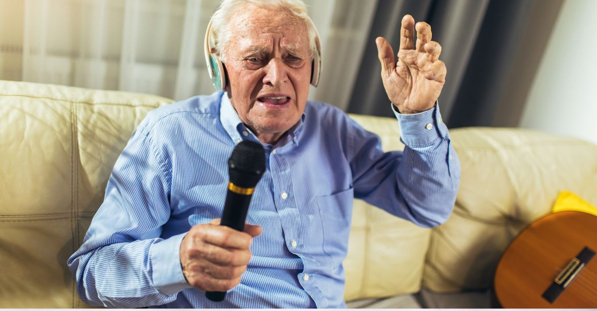 anziano seduto sul divano, canta al microfono