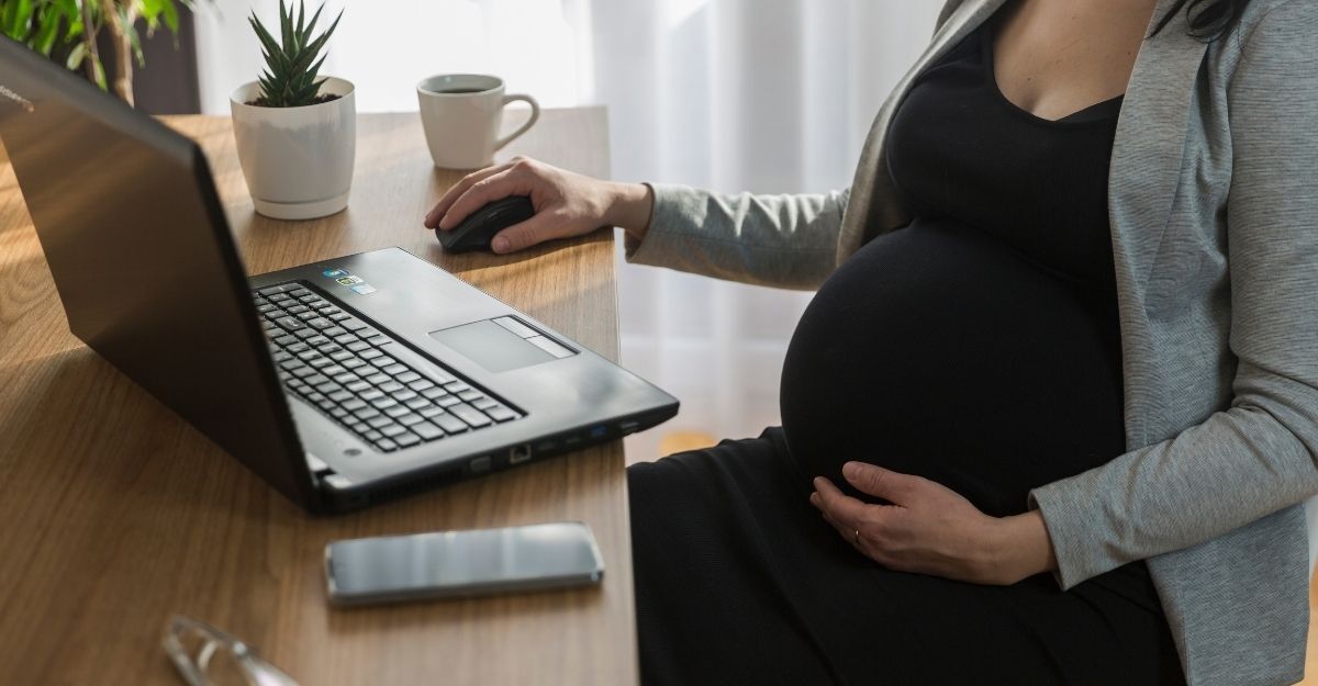 Donna incinta lavora al computer portatile e al cellulare, per lavoro. Essere incinta al lavoro. Donna incinta lavora al computer portatile a casa