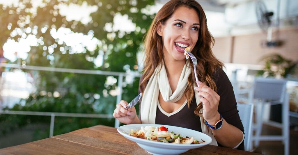 ragazza sorridente mangia un piatto sano