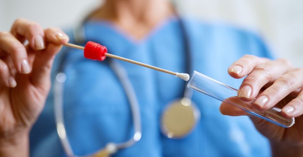 infermiera tiene in mano un tampone e una fialetta
