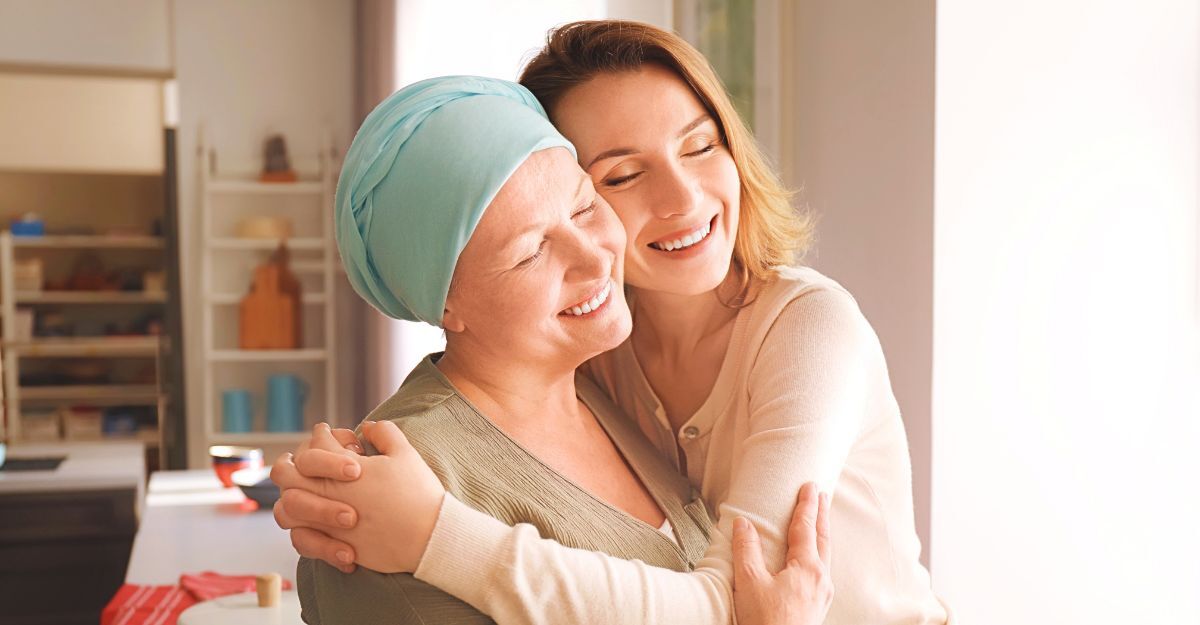 Una donna con il cancro abbraccia un'altra donna.