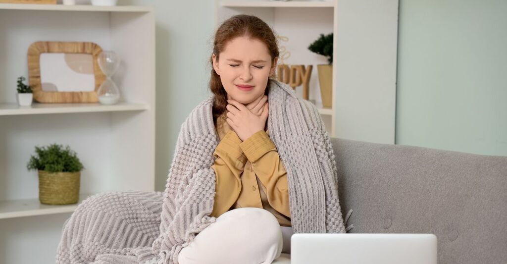 Una donna con gola, naso e polmoni irritati in una casa con aria secca