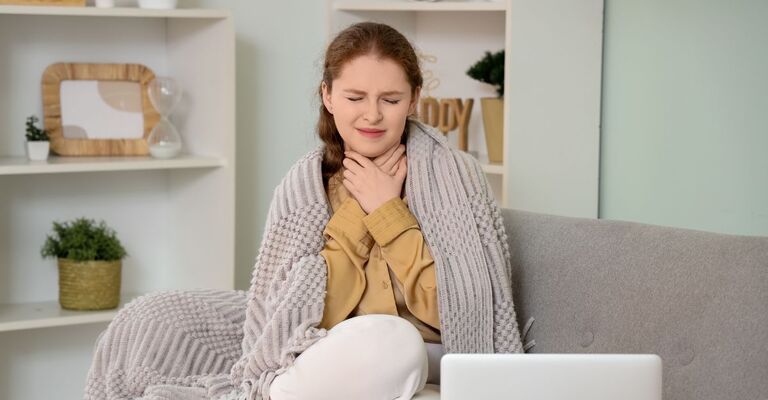 Una donna con gola, naso e polmoni irritati in una casa con aria secca