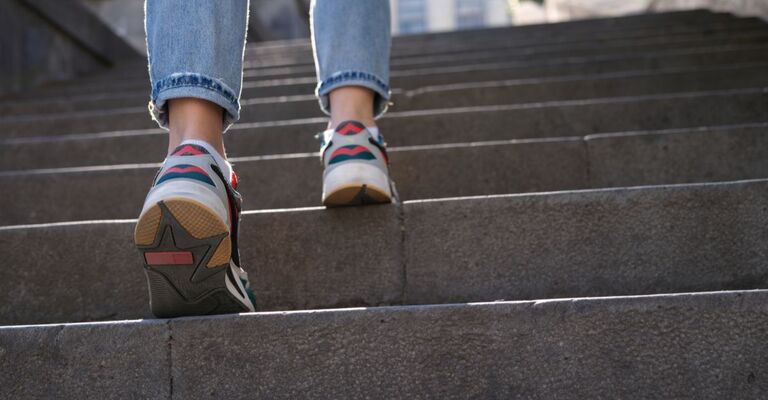 Il primo piano di una persona che sale le scale