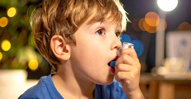 Un bambino che utilizza l'inalatore contro l'asma