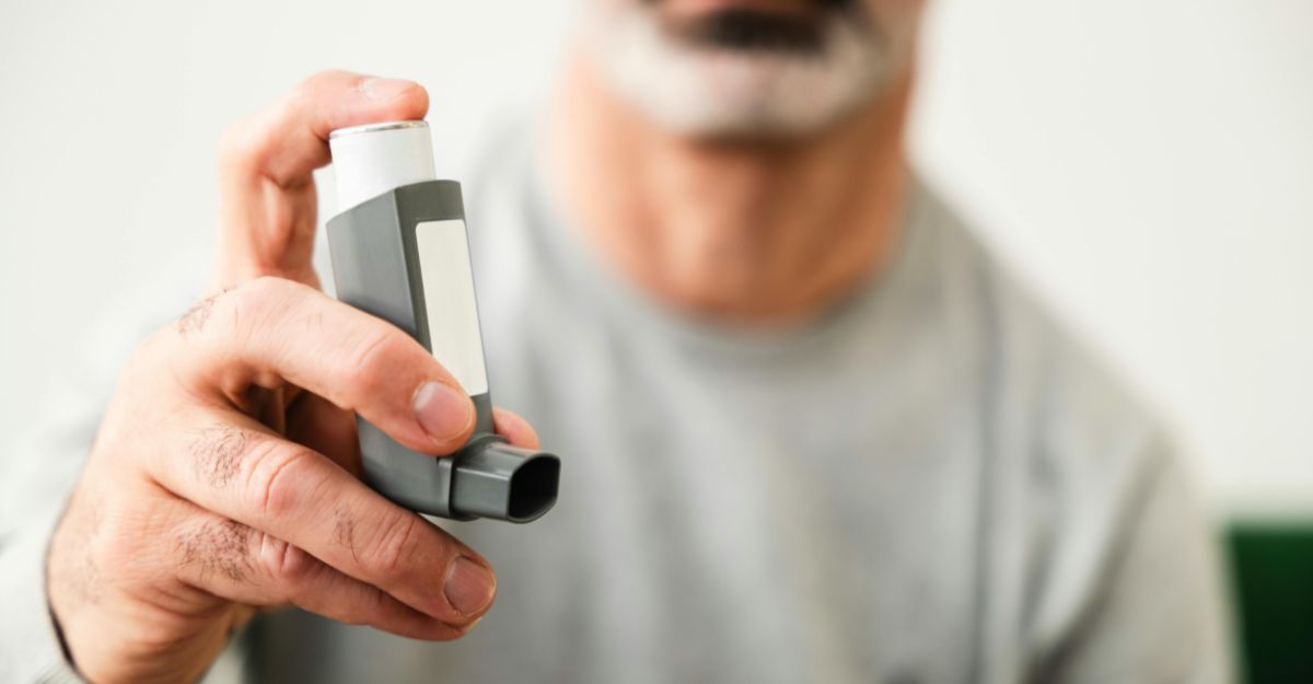 Un signore che tiene in mano l'inalatore contro l'asma