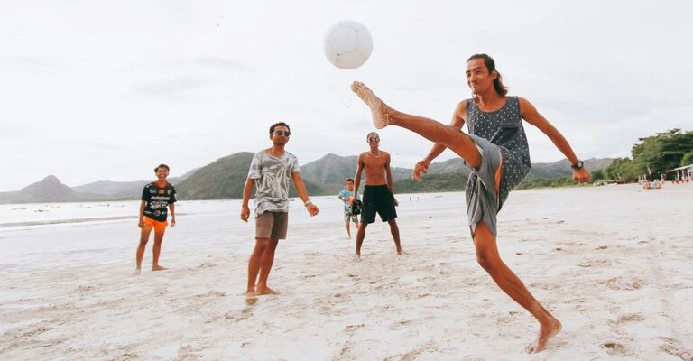 Alcuni ragazzi fanno attività fisica in spiaggia.