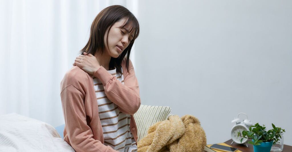 Una donna con carenze invernali ha dolori muscolari al collo.