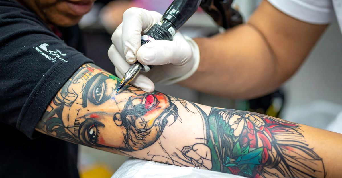 Un tatuatore che tatua un cliente