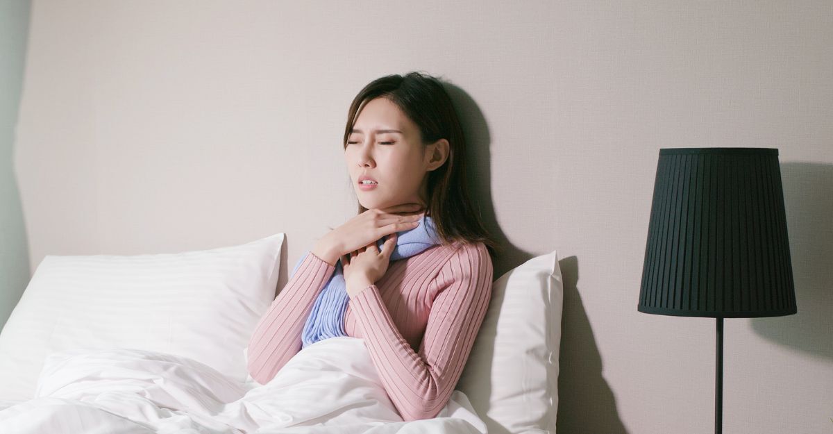 Una donna con mal di gola ricorrente a letto in camera.
