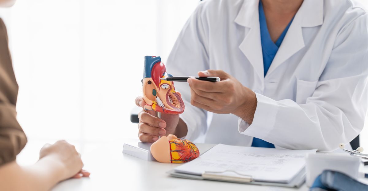 cardiologo mostra a paziente cuore cartonato