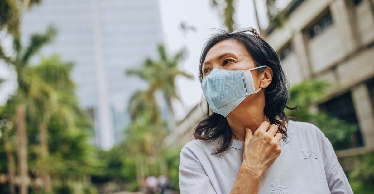 Una donna in un paese tropicale si protegge dalle malattie tropicali con la mascherina.
