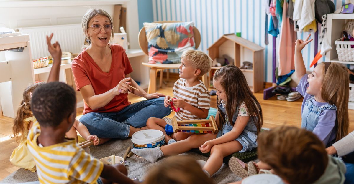 Un'insegnante di scuola materna conduce un'attività interattiva divertente con i bambini seduti in cerchio, che alzano le mani e sorridono in un'aula luminosa