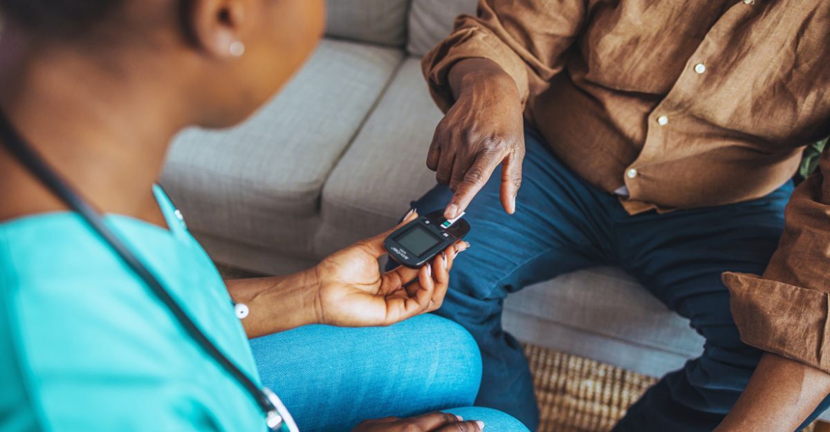 Un uomo anziano diabetico viene visitato a casa da un'infermiera distrettuale. L'infermiera sta misurando i suoi livelli di glicemia. Trattamento del diabete a domicilio