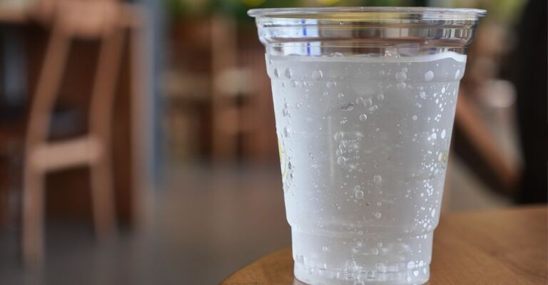 bicchiere di acqua frizzante appoggiato sul tavolo