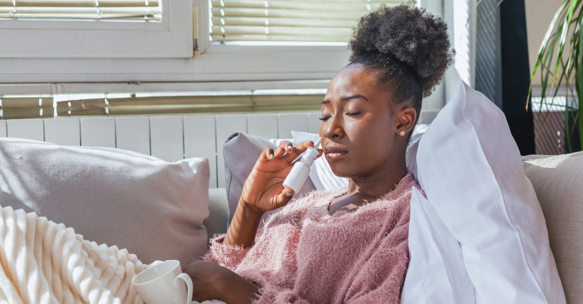 Una donna ha l'influenza e usa uno spray nasale per aiutarsi. Donna che usa uno spray nasale. Spray nasale per alleviare il raffreddore. Malata di rinite con naso che cola. Una donna applica uno spray nasale.