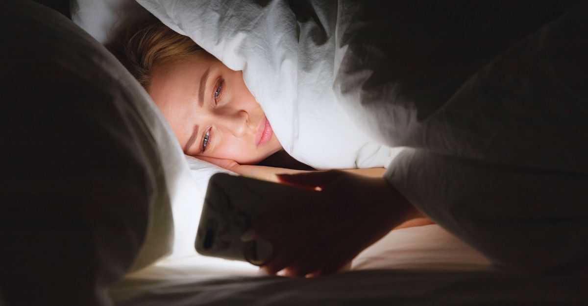 Una donna a letto tardi usa il telefono.