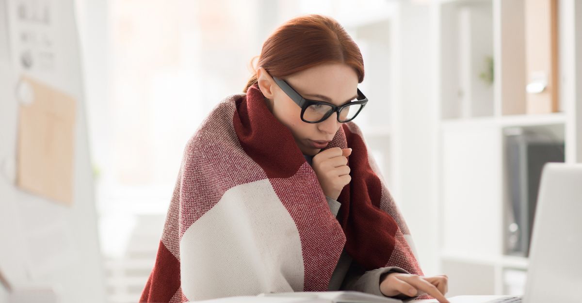 ragazza lavora al pc coperta da una trapunta