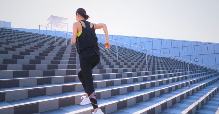 Una donna nella sua forma fisica migliore sale gli scalini.