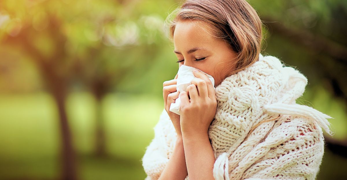 Una donna con allergia prima della primavera soffia il naso.