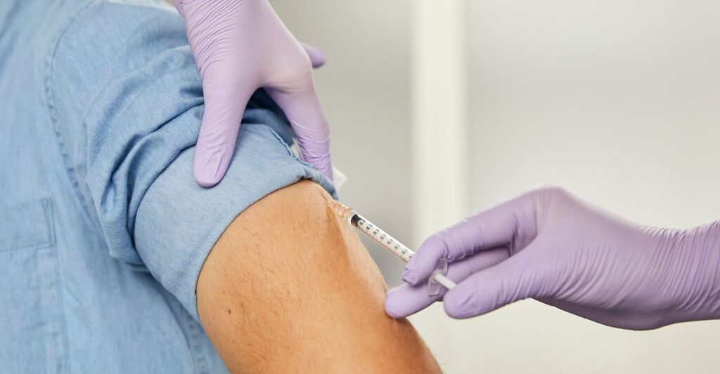 uomo riceve una puntura di vaccino al braccio