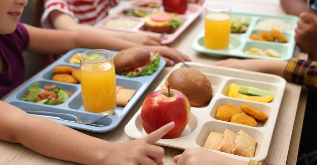 bambini mangiano alla mensa della scuola