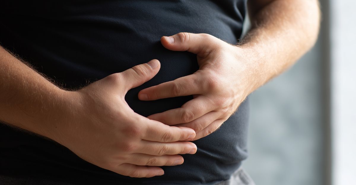 uomo si tiene la pancia dolorante