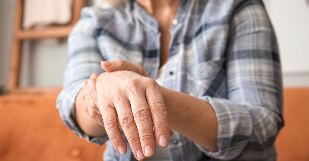 Una persona anziana che si tiene la mano