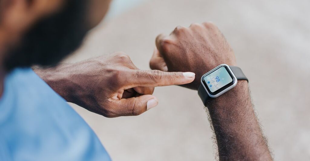 uomo controlla il suo smartwatch al polso