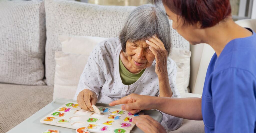 Un'infermiera con una donna che soffre di Alzheimer.
