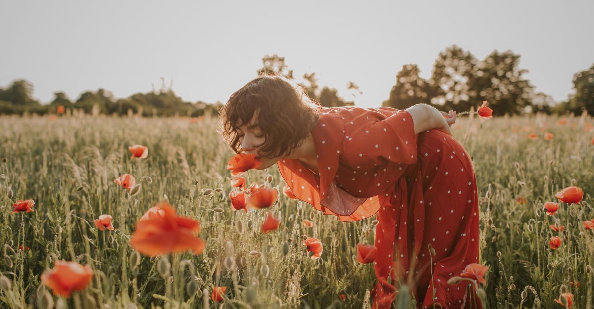 Una donna annusa i fiori di campo.
