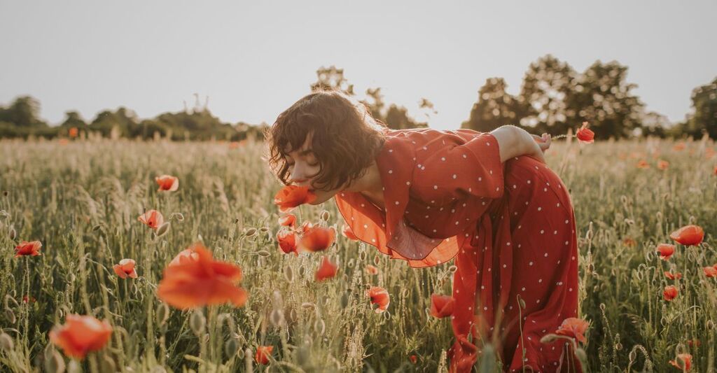 Una donna annusa i fiori di campo.