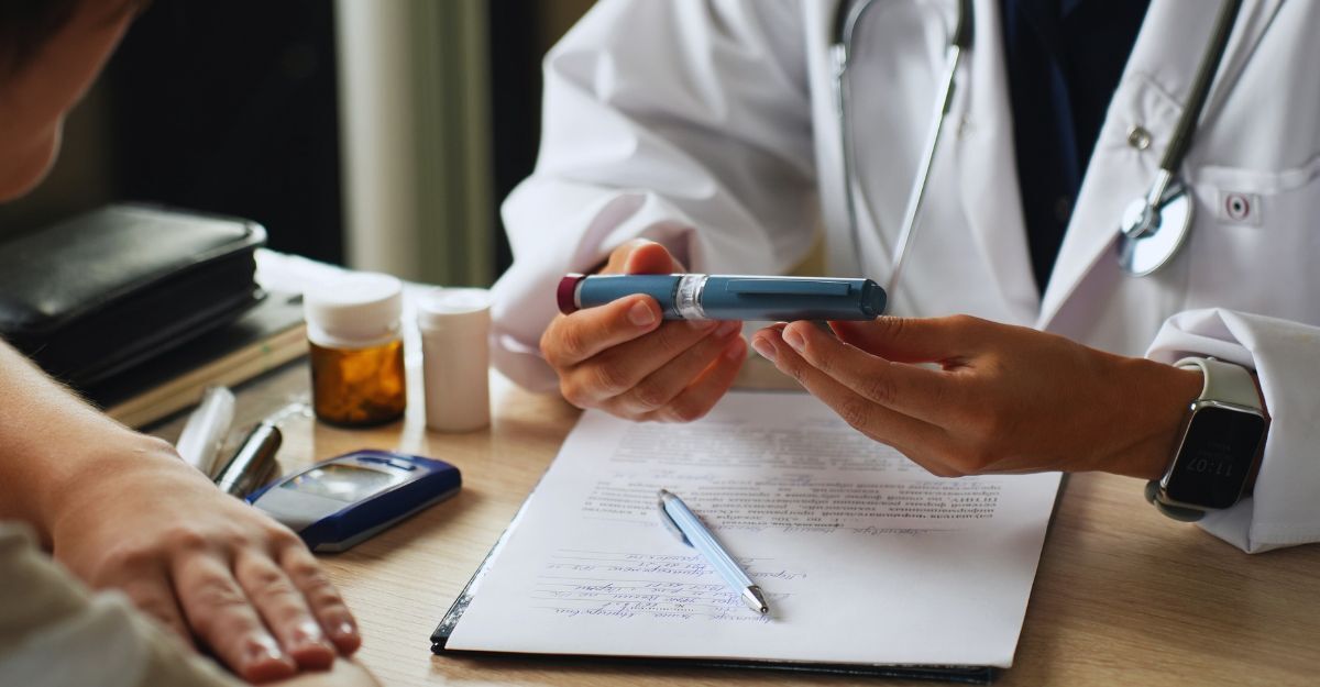 Il medico spiega come usare una penna per insulina a un paziente